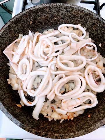 Жареные кальмары в сметане с луком на сковороде
